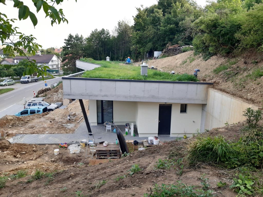 Rozostavaný podzemný dom v Trenčíne so zatrávnenou strechou, vetracími rúrami a terasou plnou náradia