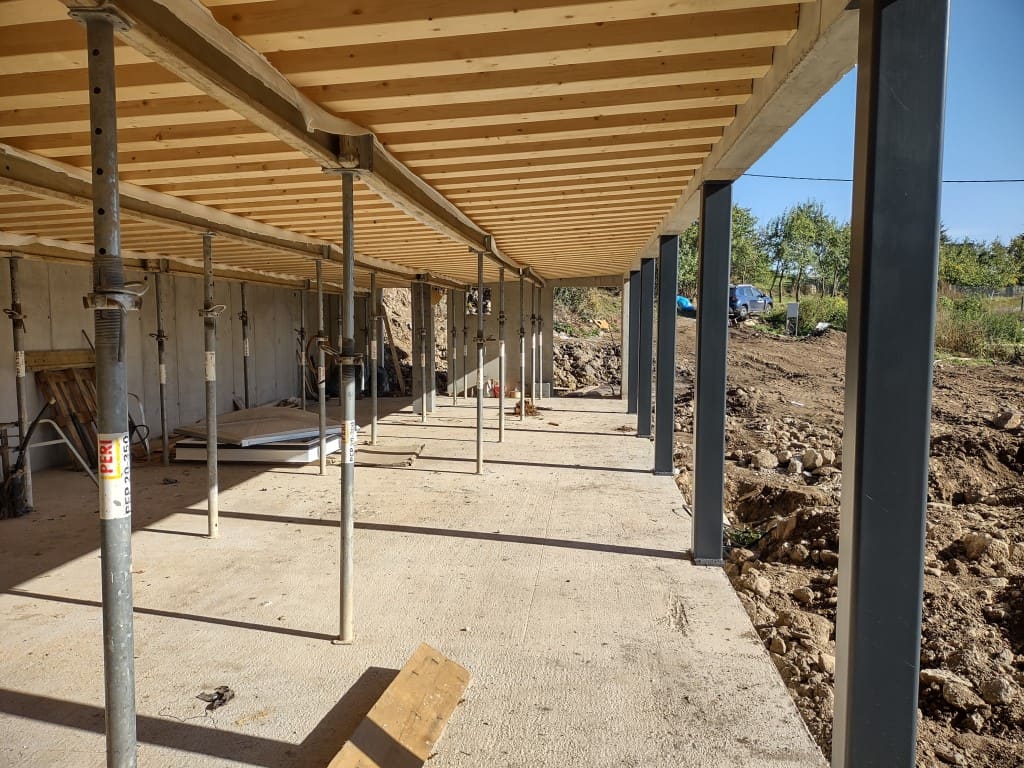 Underground home terrace roof under construction, wood joists on PERI steel props over concrete slab