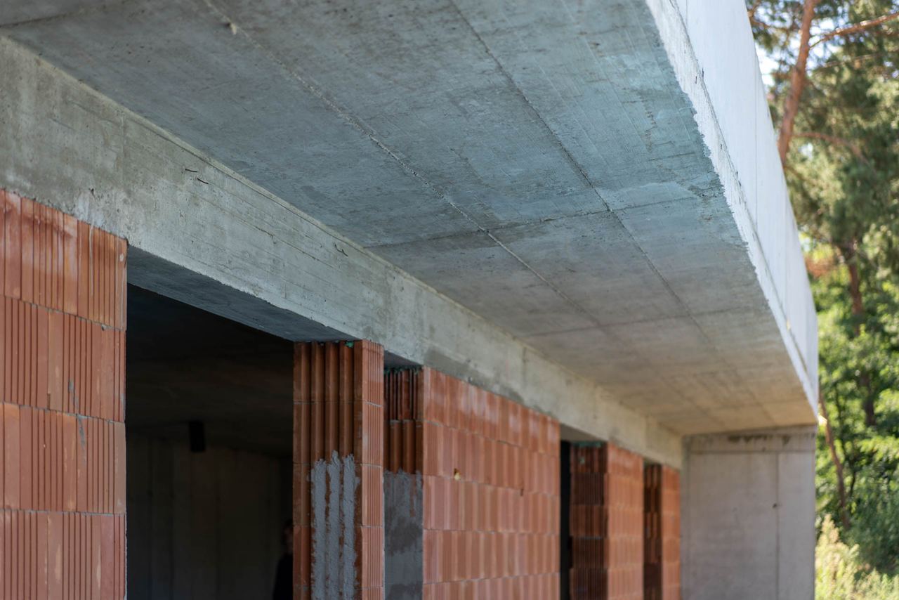 Terracotta brick walls under a concrete roof slab during earth-sheltered home construction