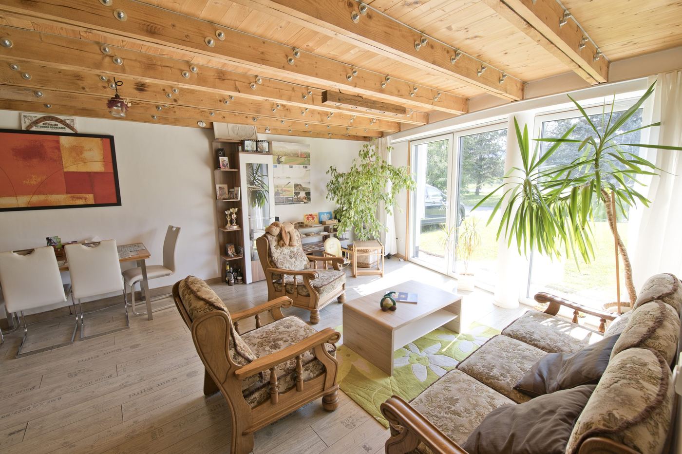 Living room of the earth-sheltered house in Rohoznik, full glass wall opening to lawn and terrace